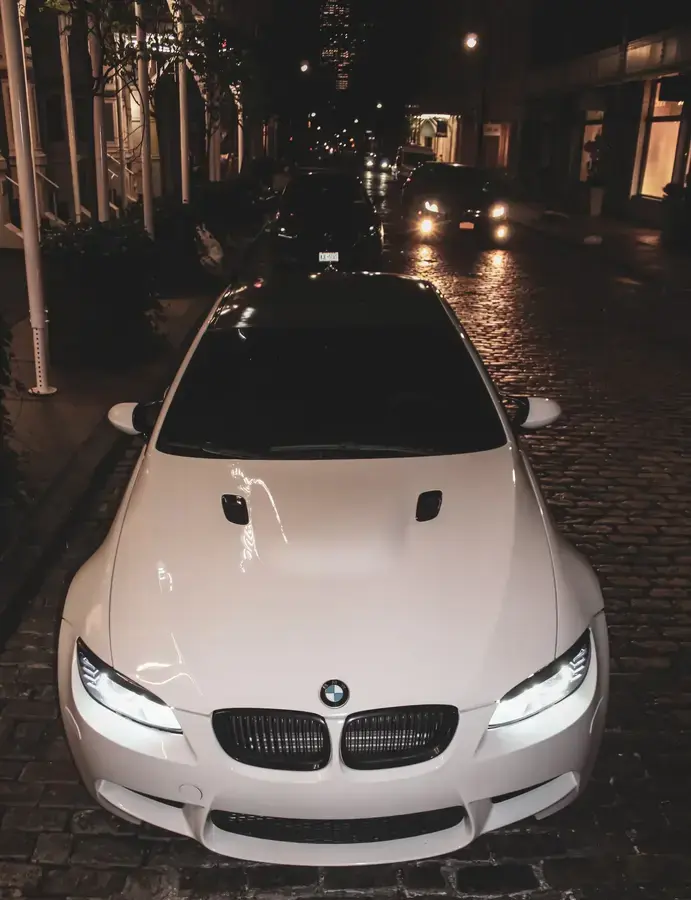 White BMW M3 street-side parking close view shot